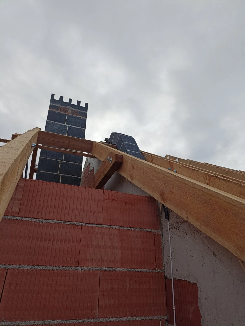 Montaż więźby dachowej nad ścianą z pustaków ceramicznych z widocznym kominem