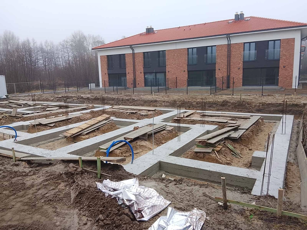 Ławy fundamentowe: betonowe podwaliny z zbrojeniem na terenie budowy szeregowca