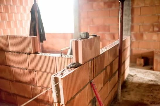 Ściany działowe z pustaków ceramicznych w trakcie murowania z linką do wypoziomowania
