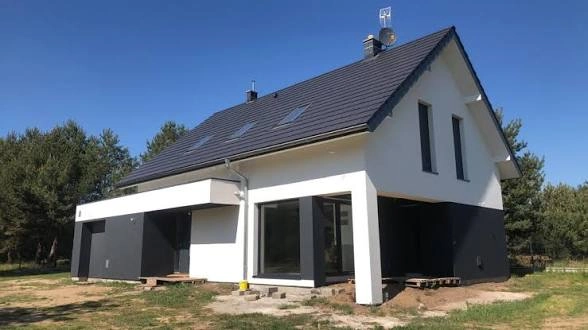 Nowoczesny dom jednorodzinny z białą elewacją i czarnym dachem, elewacja domu z dużymi przeszkleniami