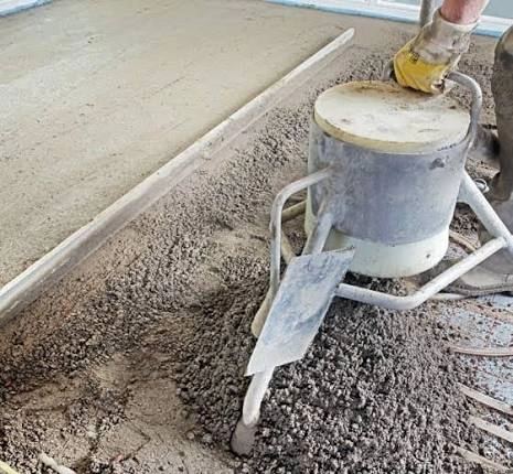 Pompa do wylewki betonowej rozprowadza beton na podłodze, umożliwiając precyzyjne wykonanie posadzki